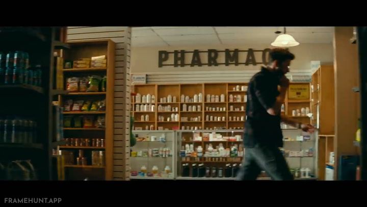 The abandoned pharmacy shelves are completely empty of soft items, but the potato chip aisle remains untouched. in A Quiet Place