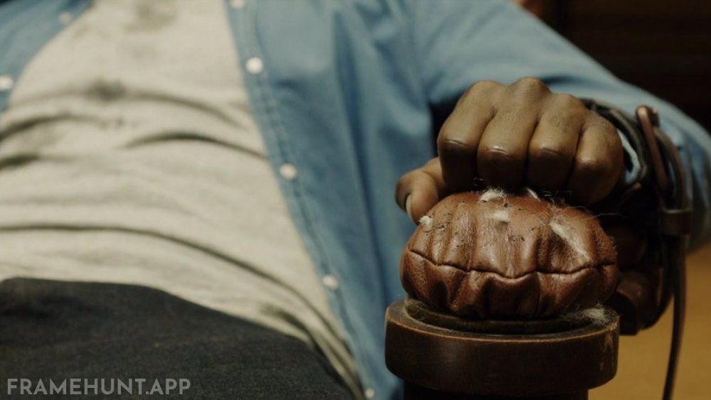 Chris literally picks cotton from the leather chair to plug his ears and escape the hypnosis. in Get Out