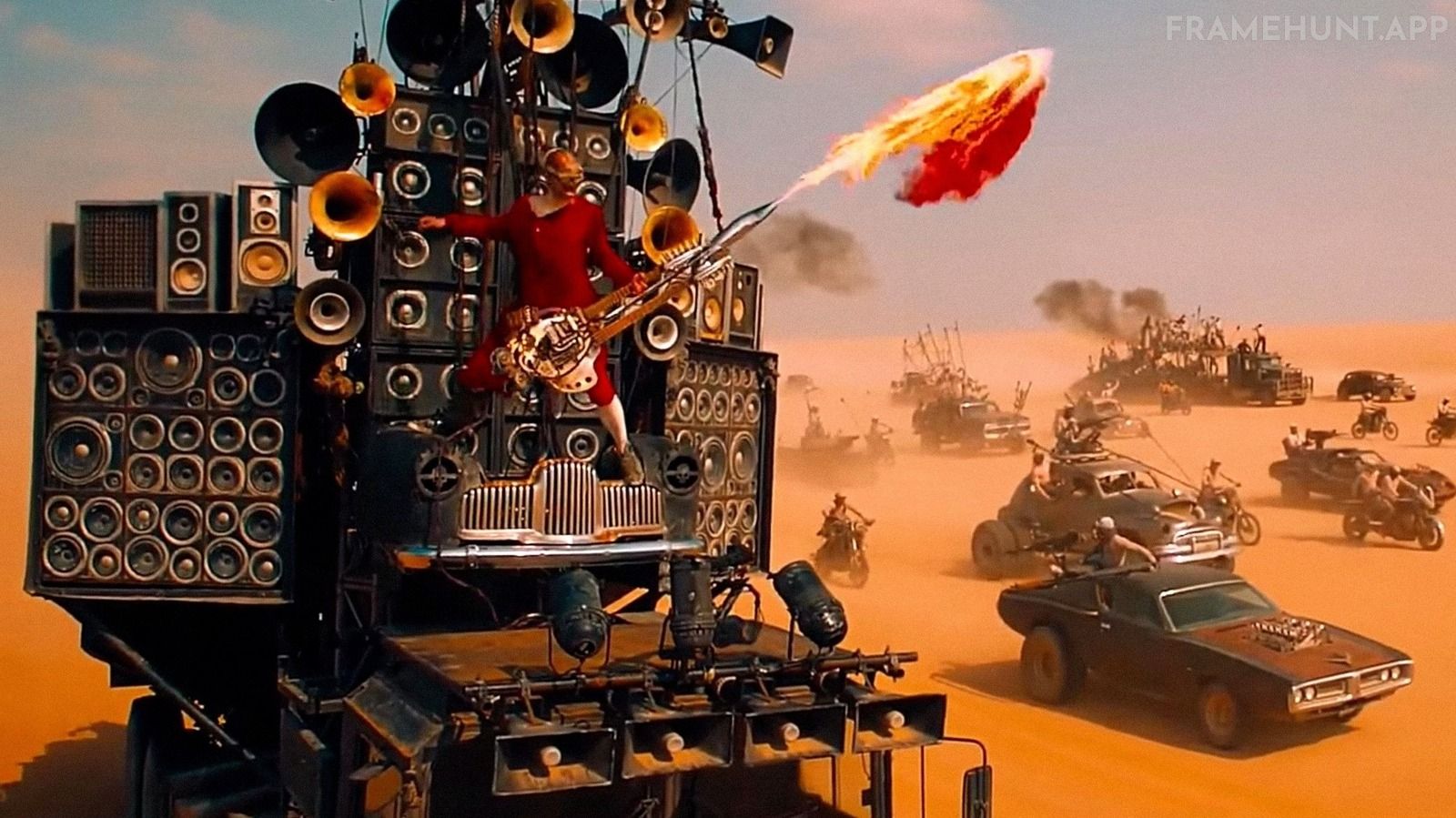 The Doof Warrior aggressively plays a heavily customized double-neck guitar that shoots massive bursts of real flames. in Mad Max: Fury Road