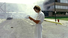 The Joker looks visibly confused and aggressively shakes a detonation remote control during a delayed hospital explosion. in The Dark Knight