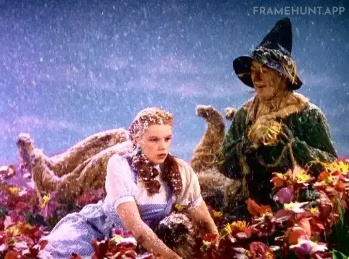 Beautiful white snow magically falls on Dorothy, the Cowardly Lion, and Toto, waking them up in the poppy field. in The Wizard of Oz