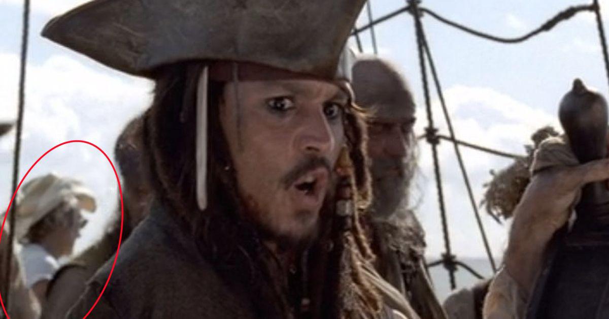 A crew member wearing a modern white cowboy hat and t-shirt is standing on the pirate ship. in Pirates of the Caribbean: The Curse of the Black Pearl
