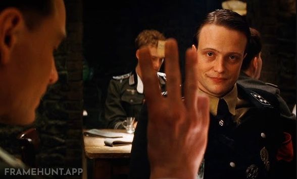 The British spy accidentally exposes his true identity by using the wrong three-finger gesture. in Inglourious Basterds