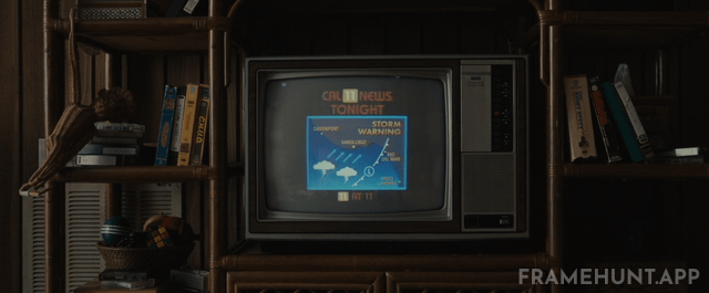 A VHS copy of the 1984 horror film C.H.U.D. is clearly displayed on the family's living room shelf. in Us